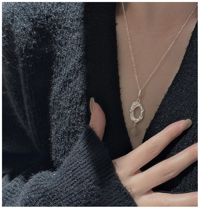 Close-up of S925 silver necklace with hammered oval pendant and translucent bead detail