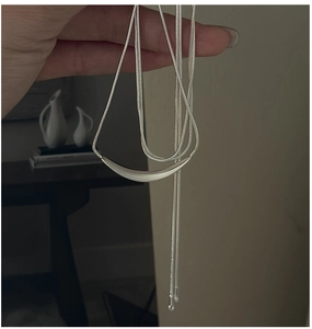 Vue détaillée du pendentif barre courbée en argent mat avec sa chaîne maille serpent
