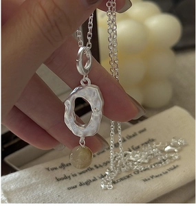 Detail of S925 sterling silver necklace with yellow crystal and hand-hammered texture