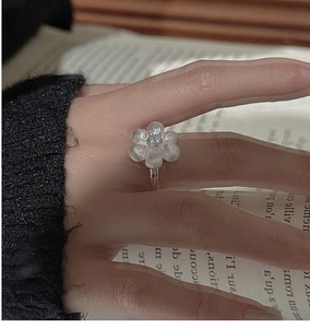 Detail of S925 sterling silver floral ring with matte texture and sparkling zircon stone