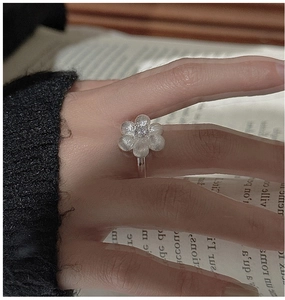 Detailed macro view of brushed S925 sterling silver flower ring with a central zircon
