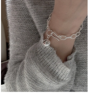 Close-up of 925 sterling silver chunky link bracelet with a metal ball pendant on wrist