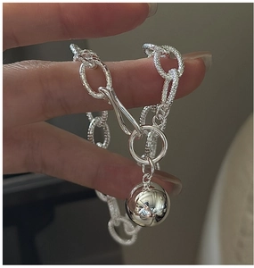 Macro shot of a 925 silver beaded chain bracelet featuring a polished mirror ball pendant