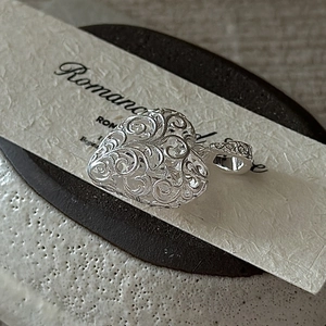 Vintage S925 sterling silver heart pendant with intricate filigree texture on card