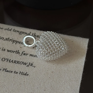 3D hollow grid heart pendant in S925 sterling silver on rustic linen background