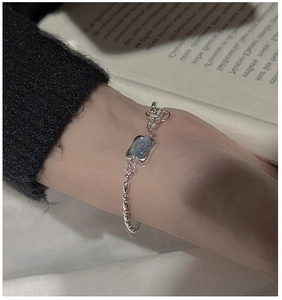Close-up of S925 sterling silver bracelet with a blue square gemstone on a model wrist
