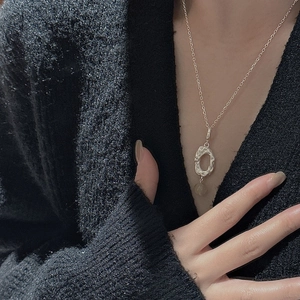 S925 sterling silver necklace with textured oval pendant and yellow crystal on a model