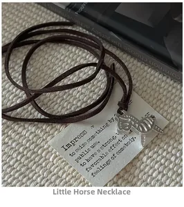 Macro detail of silver zebra pendant with vintage multi-layer faux suede cord