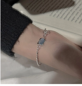 Detail of S925 silver beaded bracelet featuring a square blue stone on a female wrist
