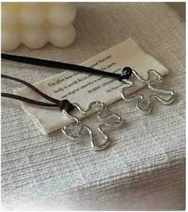 Detailed view of S925 sterling silver flower pendant on dark brown suede cord necklace