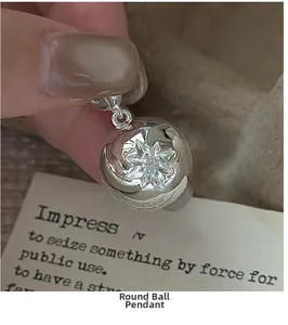 Detailed close-up of a silver S925 sterling silver ball pendant with a star pattern