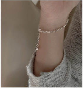 Detail of S925 sterling silver chain bracelet with round links and a small bead pendant