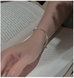 Detail of silver S925 woven bracelet with brushed metal texture and adjustable chain