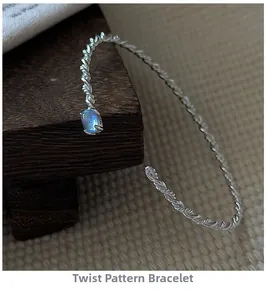 Macro shot of silver twisted bangle featuring a vintage oval blue gemstone inlay