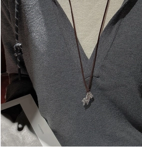Detailed view of an S925 silver zebra pendant on a brown braided rope necklace