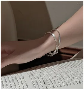 Detail of silver S925 woven textured bracelet on model wrist with soft lighting