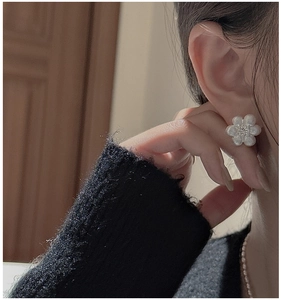 Détail de boucles d'oreilles marguerite en argent S925 avec texture brossée et zircon