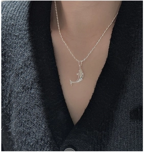 Detailansicht einer S925 Silber-Delfin-Halskette auf einem schwarzen Strickkardigan