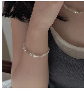 Detailed view of S925 sterling silver pleated texture bracelet on a model wrist