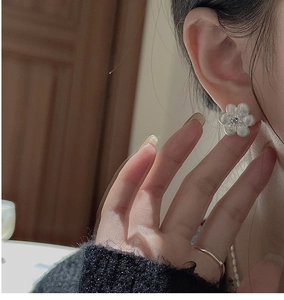 Détail de boucles d'oreilles fleurs en argent S925 avec texture brossée et zircon blanc
