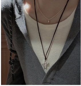 Close-up of S925 silver zebra pendant necklace layered with minimalist silver chain