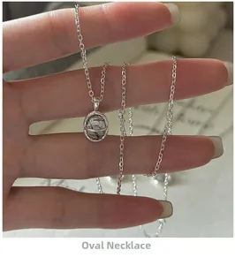 Vue macro d'un pendentif ovale en quartz rutilé noir sur une chaîne fine en argent S925