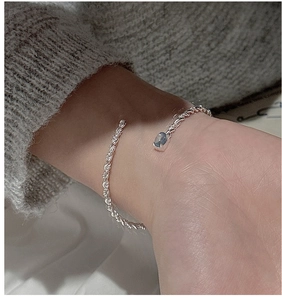 Detail of S925 sterling silver twisted rope bracelet with an oval blue gemstone inlay