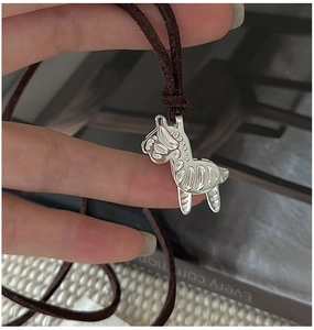 Close-up of S925 sterling silver zebra pendant with brown velvet cord necklace