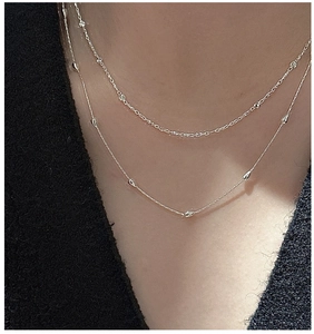 Gros plan d'un collier double rang en argent S925 avec perles et pendentifs gouttes
