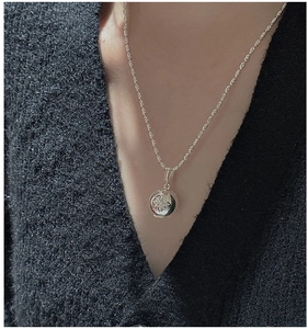 Detailed view of an S925 sterling silver hexagram coin pendant necklace on a model