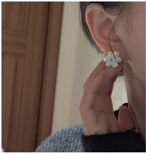 Détail de la boucle d'oreille fleur en argent S925 avec texture mate et pierre zircon