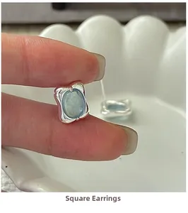 Detailed shot of S925 silver square earrings with blue gemstone in liquid metal design