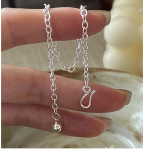 Close-up of S925 sterling silver chain with S-hook clasp and a small ball pendant