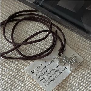 Detailed view of S925 silver zebra pendant with textured stripes on dark leather cord