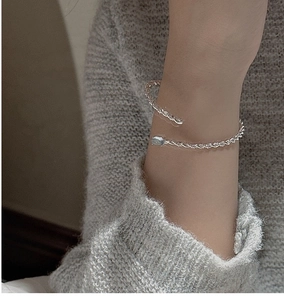Macro detail of silver twisted rope cuff bracelet with inset round grey-blue gemstone