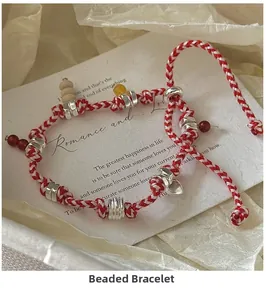 Detailed shot of S925 silver woven bracelet with beads and heart charm on paper