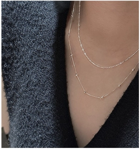 Close-up of double-layered gold S925 silver necklace with minimalist geometric beads