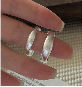 Macro shot of minimalist matte S925 sterling silver rings with organic flowing shapes