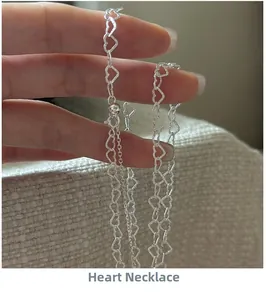 Macro shot of silver heart-shaped chain links with an adjustable sliding bead clasp