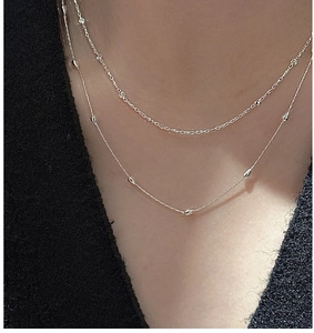 Gros plan d'un collier double épaisseur en argent S925 avec petites perles de métal