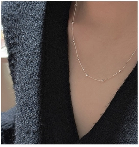 Detail of S925 sterling silver minimalist box chain necklace worn on neck