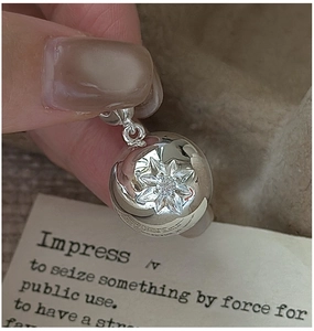 Macro shot of S925 silver sphere pendant with engraved star and zircon centerpiece