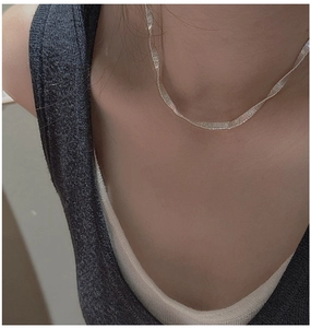 Detail shot of a silver S925 sterling silver necklace featuring a unique flat wavy texture