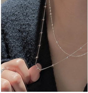 Macro shot of double layered S925 sterling silver box chain necklaces on neck