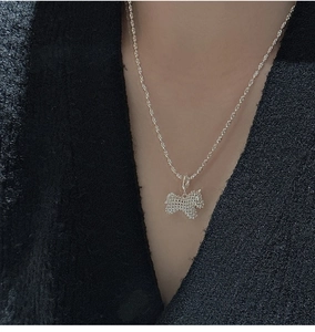 Close-up of a vintage S925 silver dog pendant necklace with textured grid detail