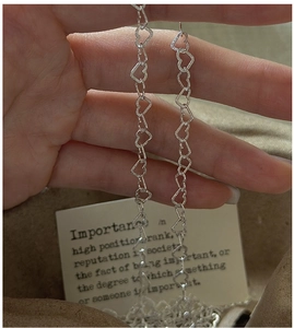 Detail of silver S925 heart-shaped link chain with a subtle shimmering matte finish