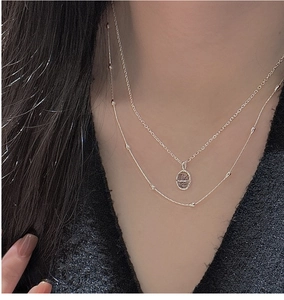 Détail du collier double rang en argent S925 avec pendentif ovale et fines perles argentées
