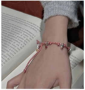 Detailed shot of S925 silver woven rope bracelet with heart charms on wrist