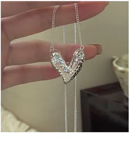 Detailed close-up of a faceted 925 sterling silver heart pendant on a delicate chain