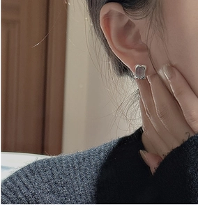 Close-up of model wearing silver S925 sterling silver earrings with purple stone